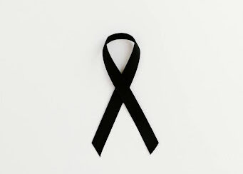 Black ribbon laying flat on an off-white background for skin cancer awareness